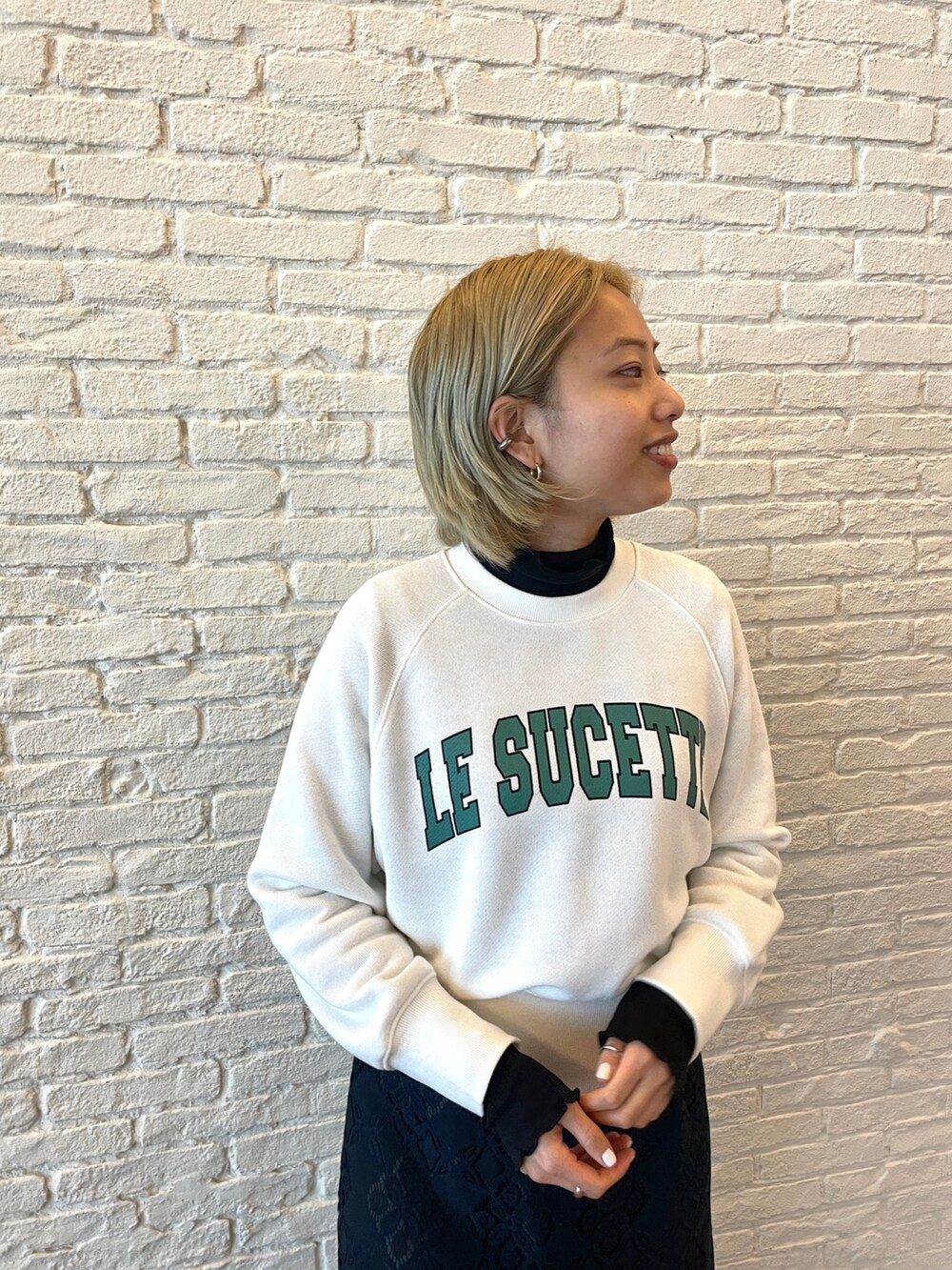 ホワイト系のスウェット、ブラック系のTシャツ/カットソー、ブルー系のスカートを着用したレディースの春コーディネートの2枚目の写真