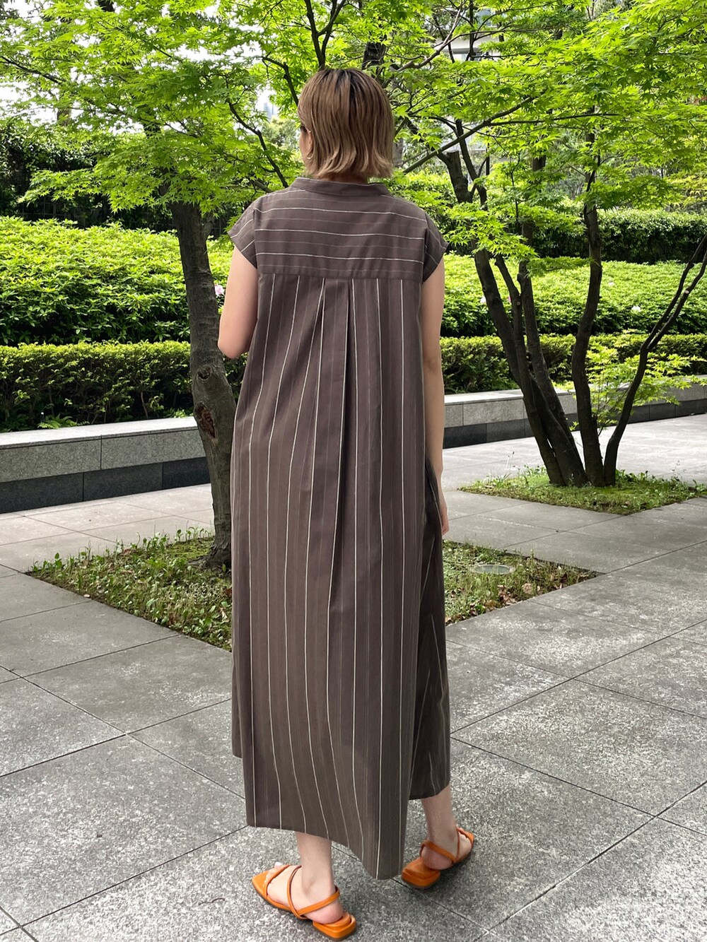 ブラウン系のワンピース、オレンジ系のサンダルを着用したレディースの春コーディネートの3枚目の写真
