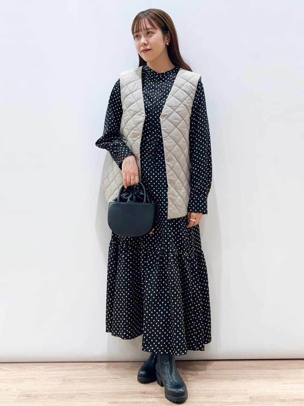 ベージュ系のブルゾン、ブラック系のワンピース、ブラック系のブーツを着用したレディースの秋コーディネートの4枚目の写真