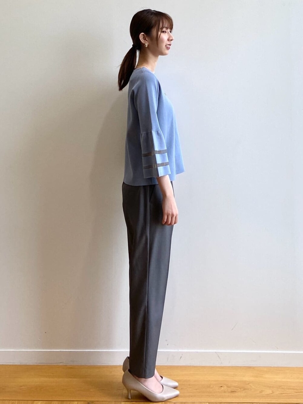 グレー系のその他パンツ、ベージュ系のパンプス、ブルー系のニット/セーターを着用したレディースの秋コーディネートの3枚目の写真