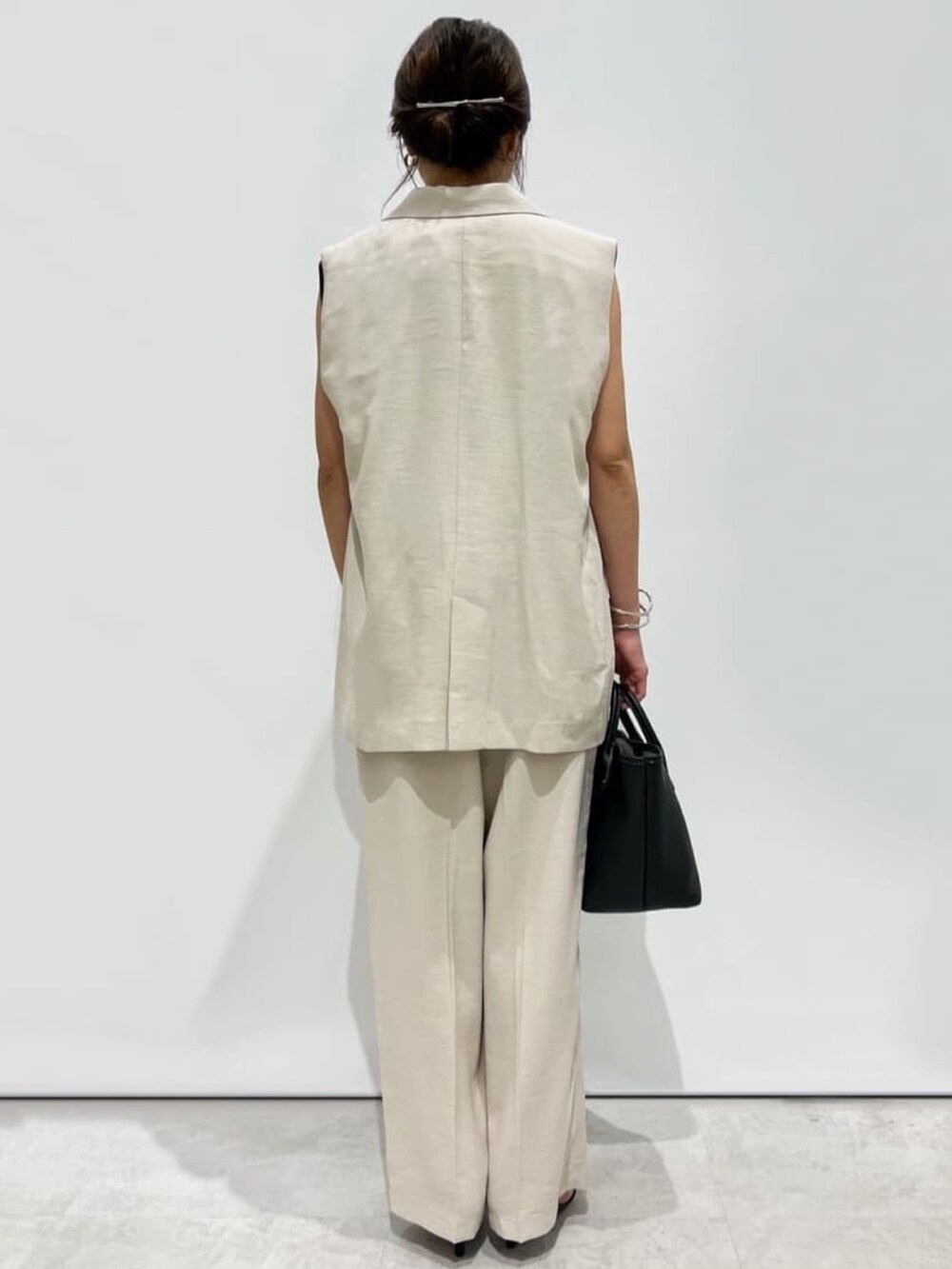 ベージュ系のその他パンツ、ブラック系のトートバッグ、ブラック系のサンダルを着用したレディースの夏コーディネートの3枚目の写真