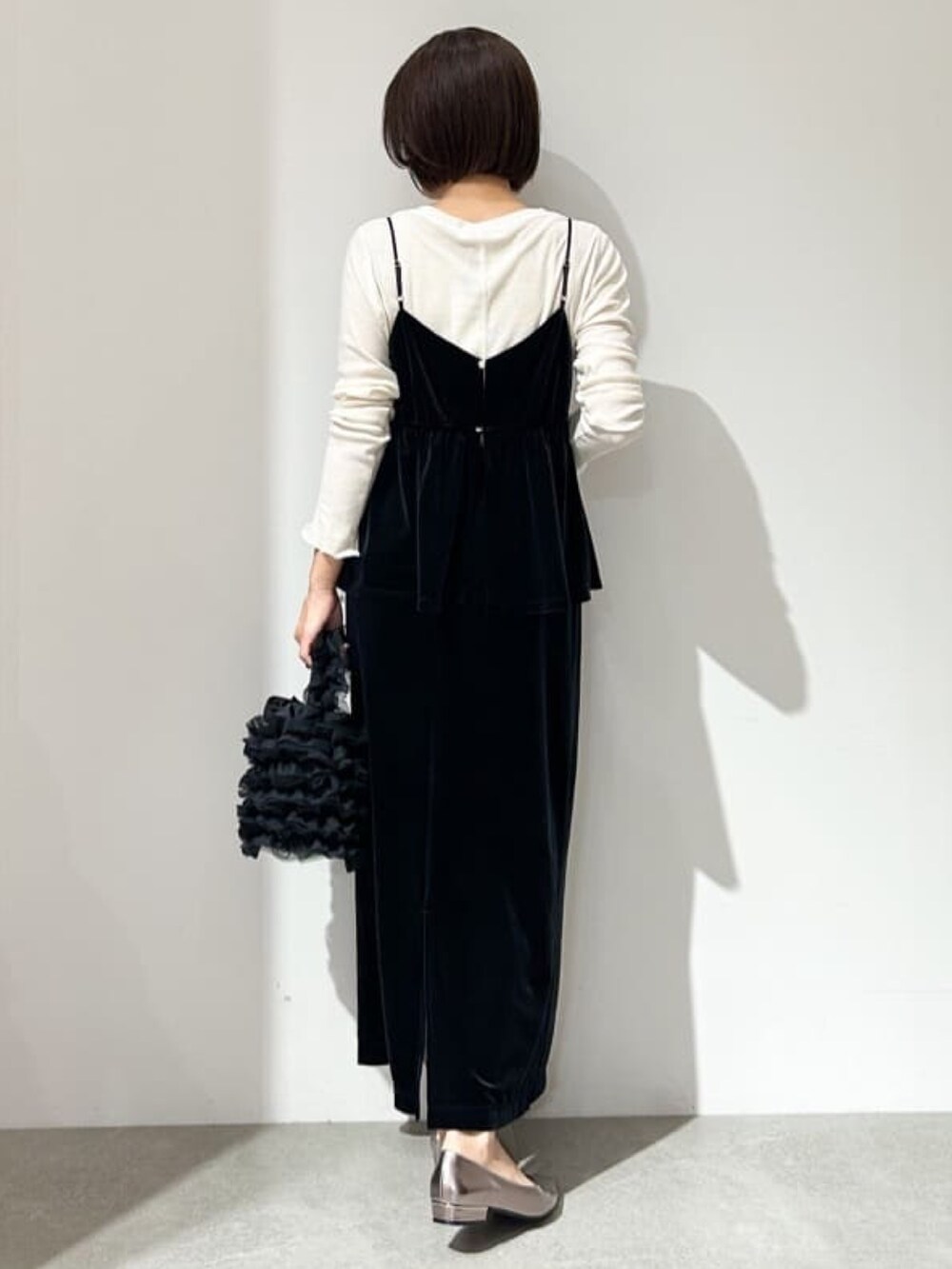 ブラック系のスカート、ブラック系のタンクトップ、ホワイト系のTシャツ/カットソーを着用したレディースの秋コーディネートの4枚目の写真