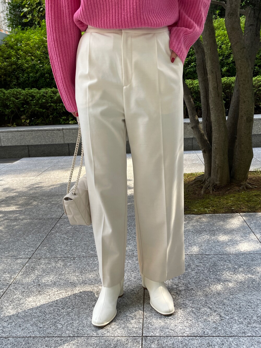 ピンク系のニット/セーター、ベージュ系のチェスターコート、ホワイト系のブーツを着用したレディースの秋コーディネートの5枚目の写真