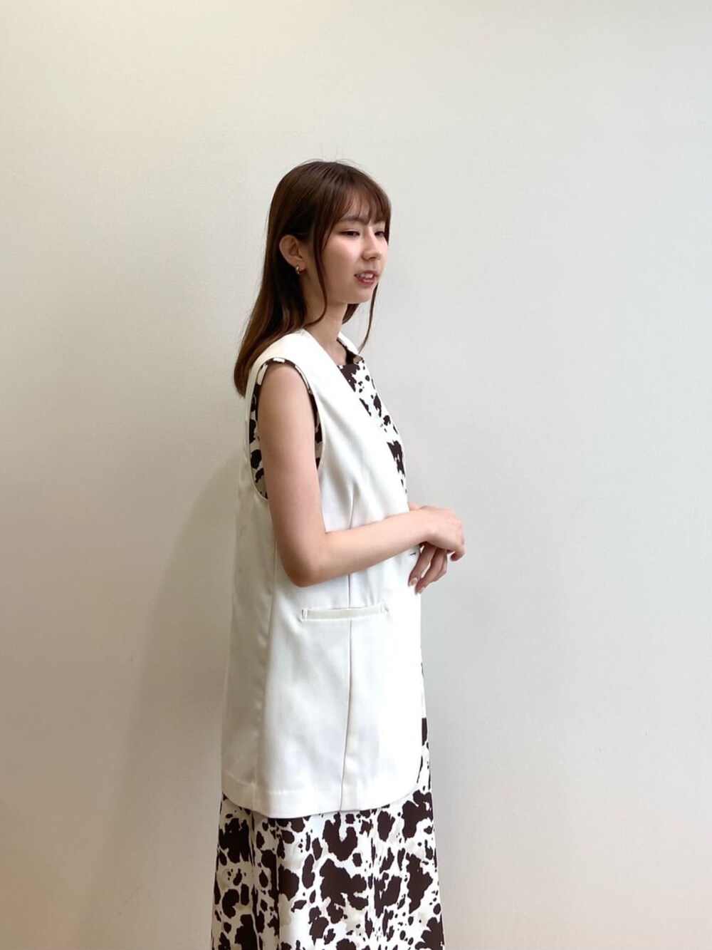 ブラウン系のワンピース、ベージュ系のベスト、シルバー系のパンプスを着用したレディースの夏コーディネートの6枚目の写真