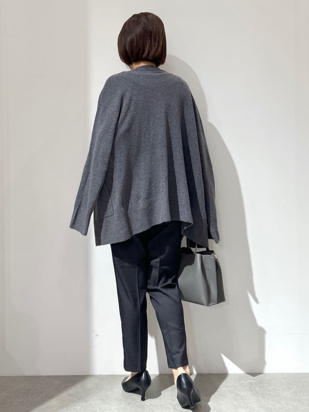 ホワイト系のTシャツ/カットソー、グレー系のカーディガン/ボレロ、ブラック系のその他パンツを着用したレディースの秋コーディネートの3枚目の写真