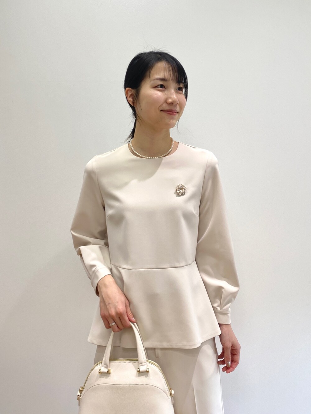 ベージュ系のシャツ/ブラウス、ベージュ系のその他パンツ、ホワイト系のパンプスを着用したレディースの冬コーディネートの2枚目の写真