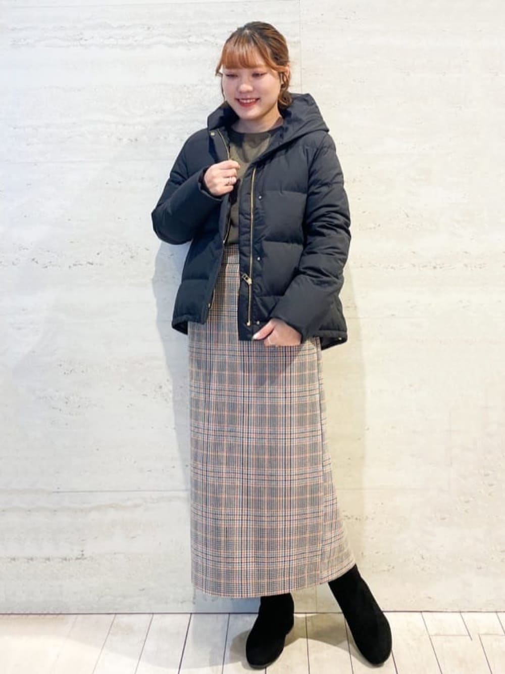 ブラウン系のニット/セーター、オレンジ系のスカート、ブラック系のショルダーバッグを着用したレディースの冬コーディネートの2枚目の写真