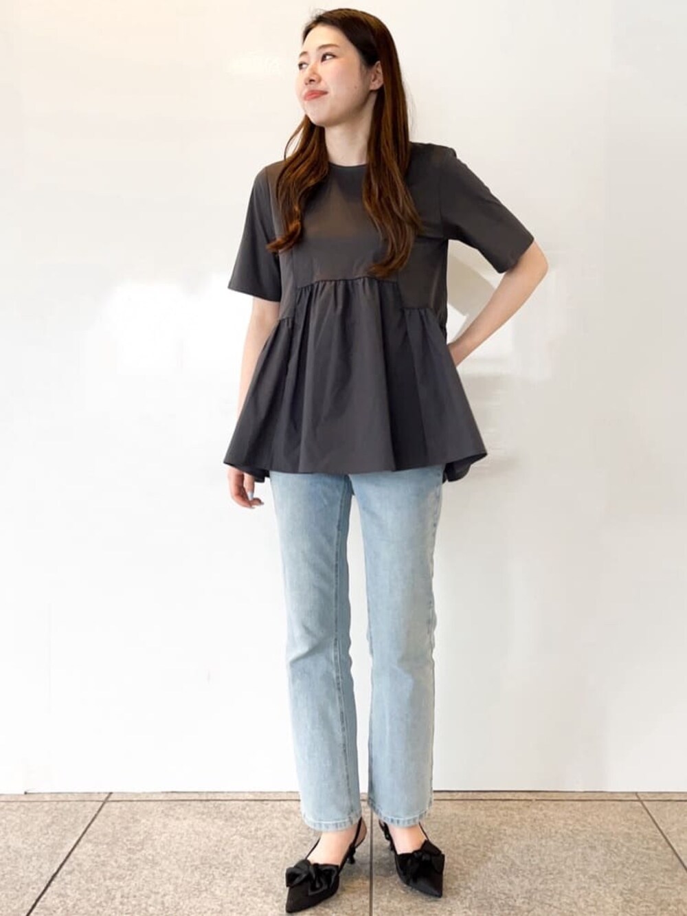 グレー系のTシャツ/カットソー、ブルー系のデニムパンツ、ブラック系のパンプスを着用したレディースの春コーディネートの2枚目の写真