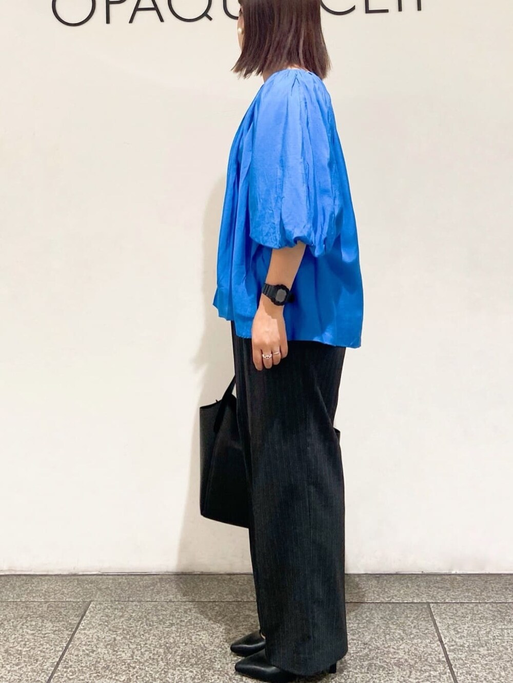 ブルー系のシャツ/ブラウス、グレー系のその他パンツ、ブラック系のトートバッグを着用したレディースの夏コーディネートの4枚目の写真