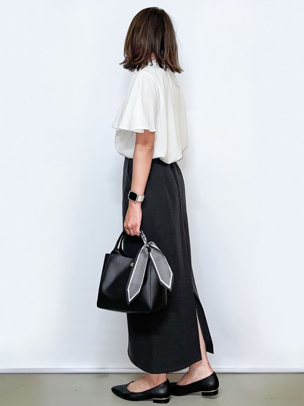 ホワイト系のシャツ/ブラウス、グレー系のスカート、ブラック系のトートバッグを着用したレディースの夏コーディネートの5枚目の写真