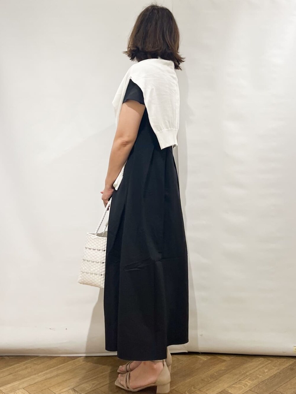 ブラック系のワンピース、ホワイト系のカーディガン/ボレロ、ホワイト系のトートバッグを着用したレディースの夏コーディネートの2枚目の写真