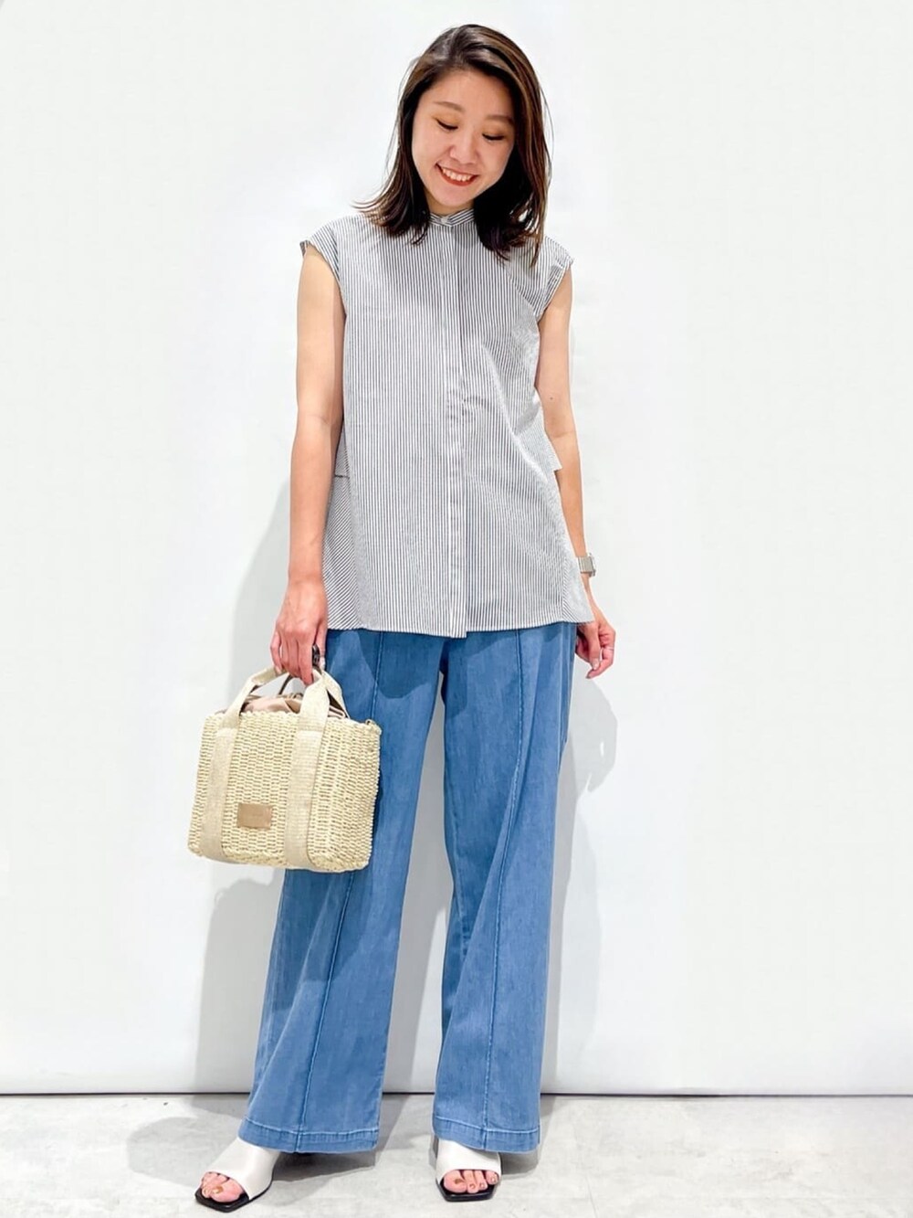 ホワイト系のシャツ/ブラウス、ホワイト系のサンダル、ゴールド系のショルダーバッグを着用したレディースの夏コーディネートの4枚目の写真