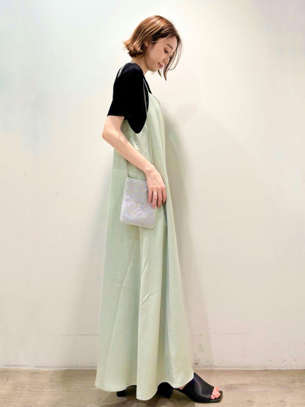 ブラック系のニット/セーター、グリーン系のワンピース、シルバー系のショルダーバッグを着用したレディースの夏コーディネートの4枚目の写真