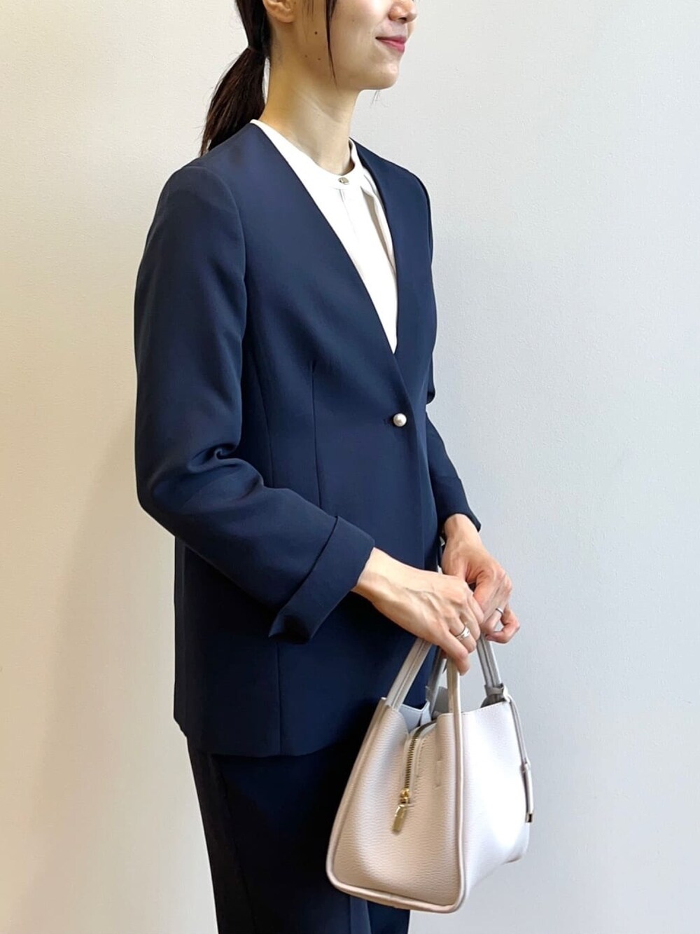 ブルー系のノーカラージャケット、ブルー系のその他パンツ、グレー系のショルダーバッグを着用したレディースの秋コーディネートの5枚目の写真