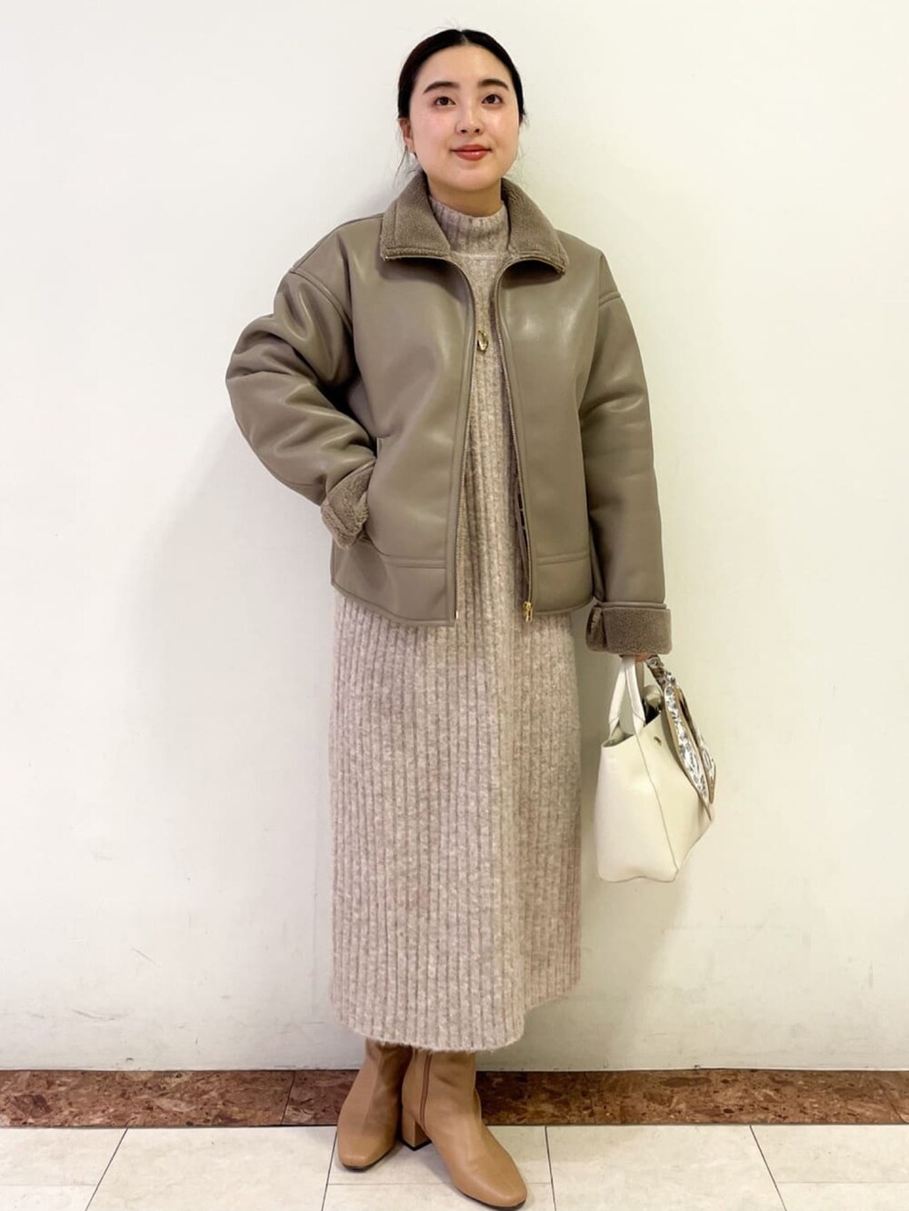 ベージュ系のブーツ、ベージュ系のワンピース、ホワイト系のトートバッグを着用したレディースの冬コーディネートの2枚目の写真