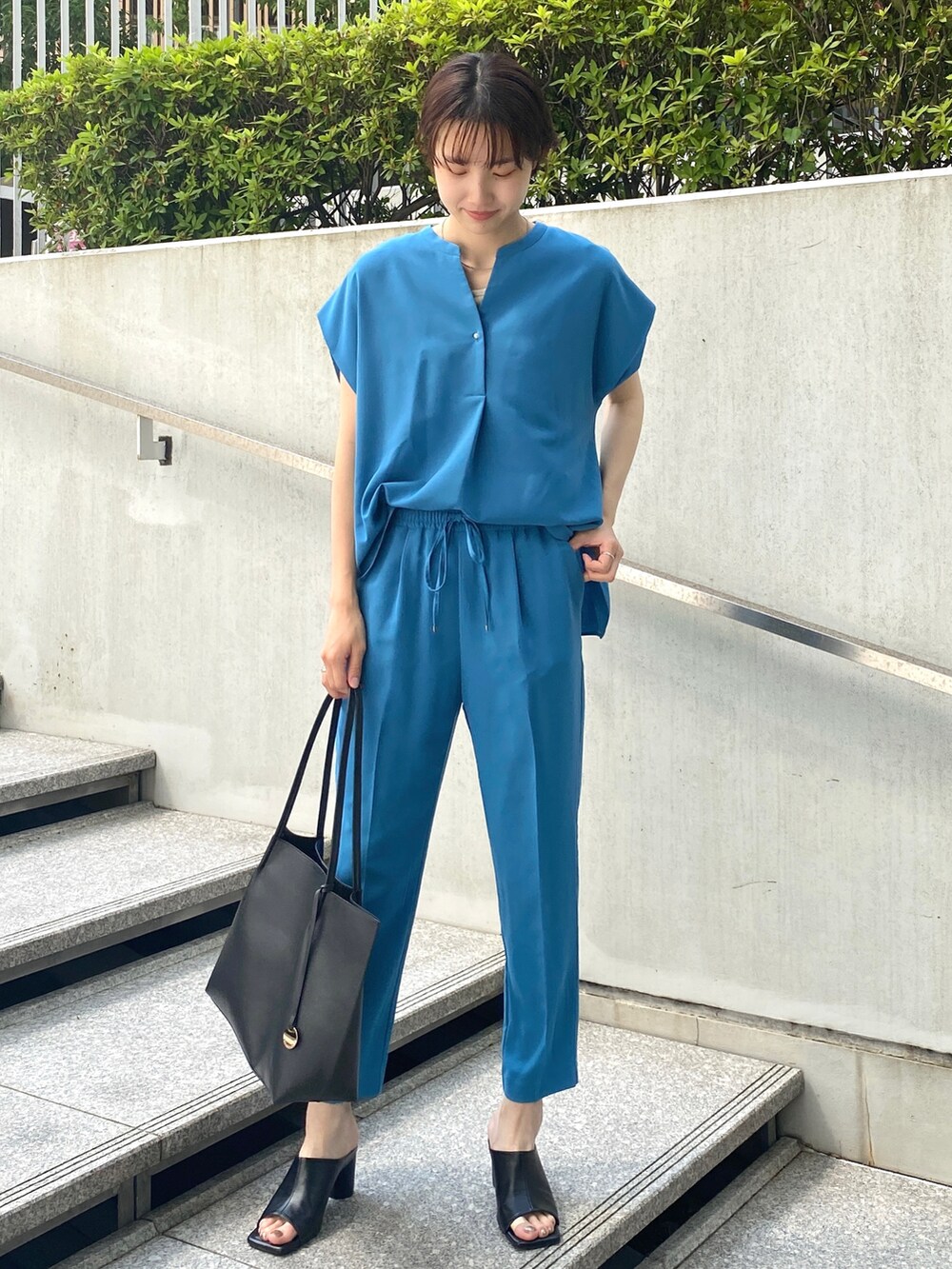 ブルー系のシャツ/ブラウス、ブルー系のその他パンツ、ブラック系のトートバッグを着用したレディースの夏コーディネートの2枚目の写真