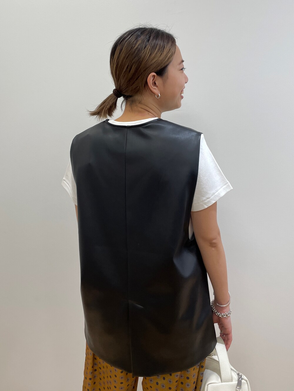 ホワイト系のTシャツ/カットソー、ブラック系のベスト、イエロー系のその他パンツを着用したレディースの夏コーディネートの4枚目の写真