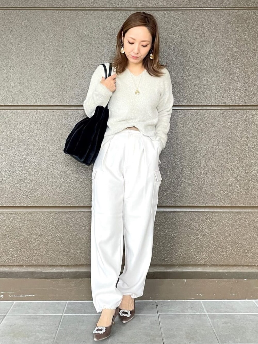 ホワイト系のその他パンツ、ブラック系のショルダーバッグ、ベージュ系のニット/セーターを着用したレディースの冬コーディネートの5枚目の写真