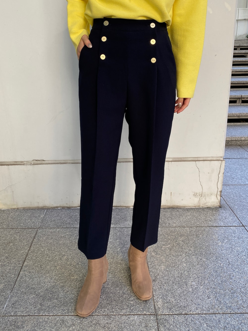 ブルー系のチェスターコート、イエロー系のニット/セーター、ベージュ系のブーツを着用したレディースの冬コーディネートの4枚目の写真