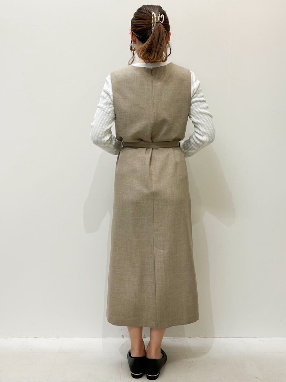 ベージュ系のワンピース、ホワイト系のニット/セーター、ブラック系のトートバッグを着用したレディースの春コーディネートの3枚目の写真