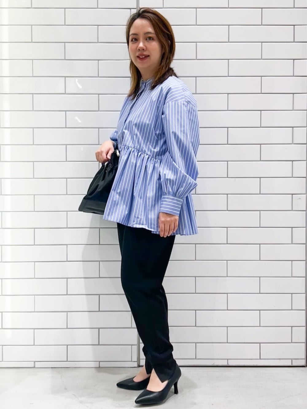 ブルー系のシャツ/ブラウス、ブラック系のその他パンツ、ブラック系のパンプスを着用したレディースの春コーディネートの2枚目の写真