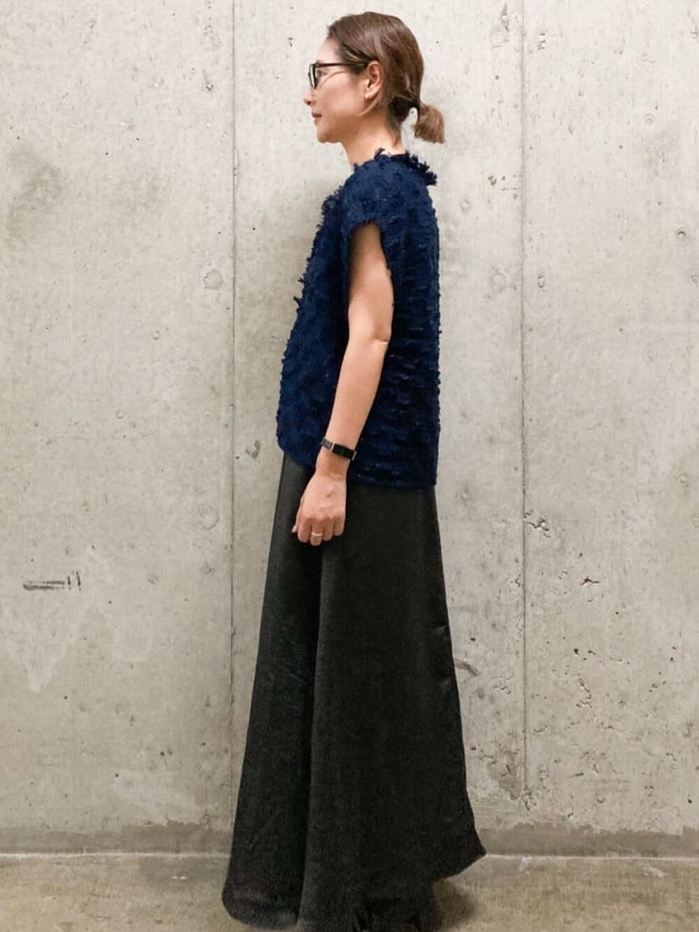 ブルー系のニット/セーター、グレー系のワンピース、ブラック系のブーツを着用したレディースの秋コーディネートの3枚目の写真