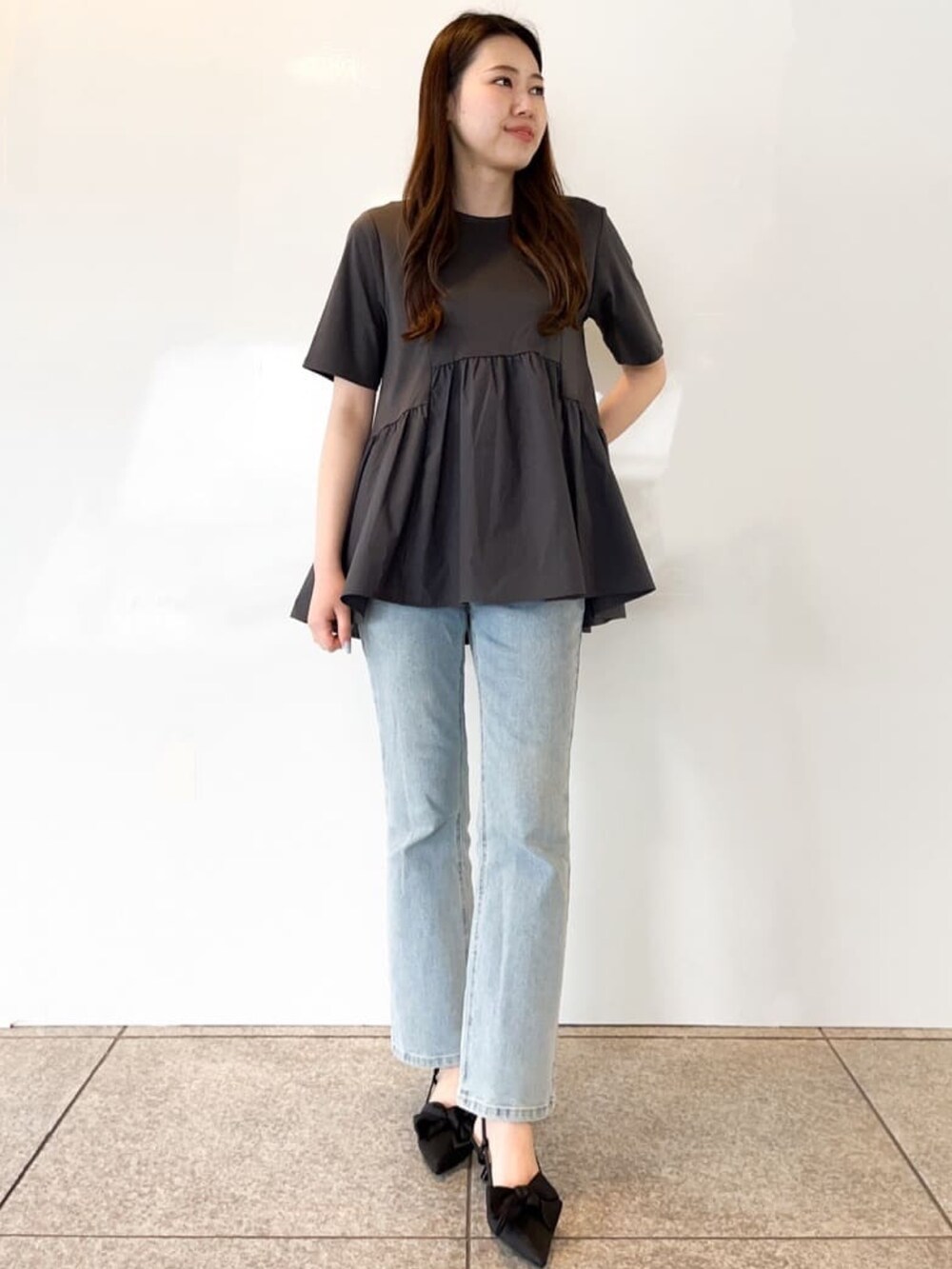 グレー系のTシャツ/カットソー、ブルー系のデニムパンツ、ブラック系のパンプスを着用したレディースの春コーディネートの3枚目の写真