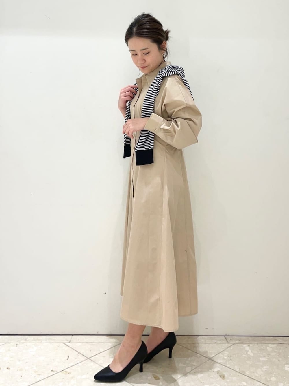 ベージュ系のワンピース、ホワイト系のカーディガン/ボレロ、ブラック系のショルダーバッグを着用したレディースの春コーディネートの2枚目の写真