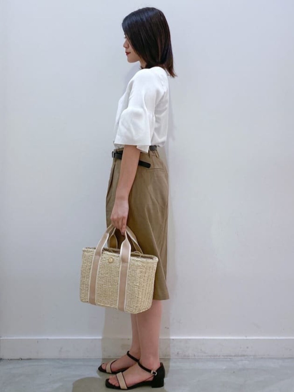 ホワイト系のニット/セーター、ベージュ系のトートバッグ、ブラウン系のその他パンツを着用したレディースの夏コーディネートの2枚目の写真