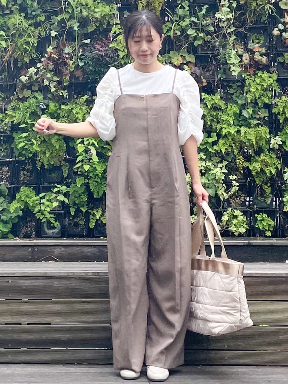 ベージュ系のトートバッグ、ベージュ系のドレスシューズ、ブラウン系のサロペット/オーバーオールを着用したレディースの秋コーディネートの2枚目の写真