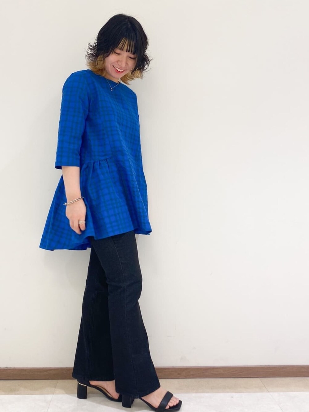 ブラック系のサンダル、ブルー系のチュニック、グレー系のデニムパンツを着用したレディースの夏コーディネートの2枚目の写真