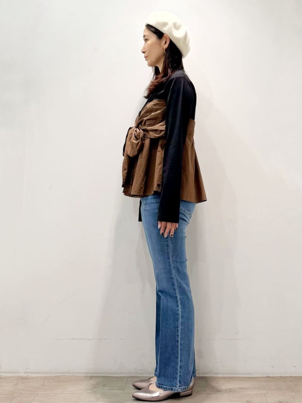 シルバー系のパンプス、ブルー系のデニムパンツ、ブラック系のTシャツ/カットソーを着用したレディースの秋コーディネートの5枚目の写真