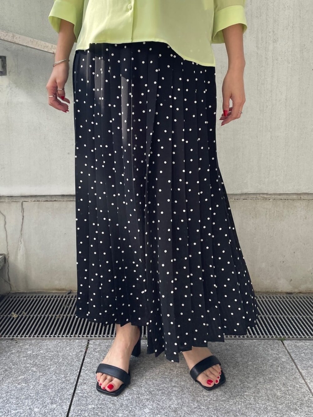 グリーン系のシャツ/ブラウス、ブラック系のスカート、ブラック系のサンダルを着用したレディースの春コーディネートの6枚目の写真