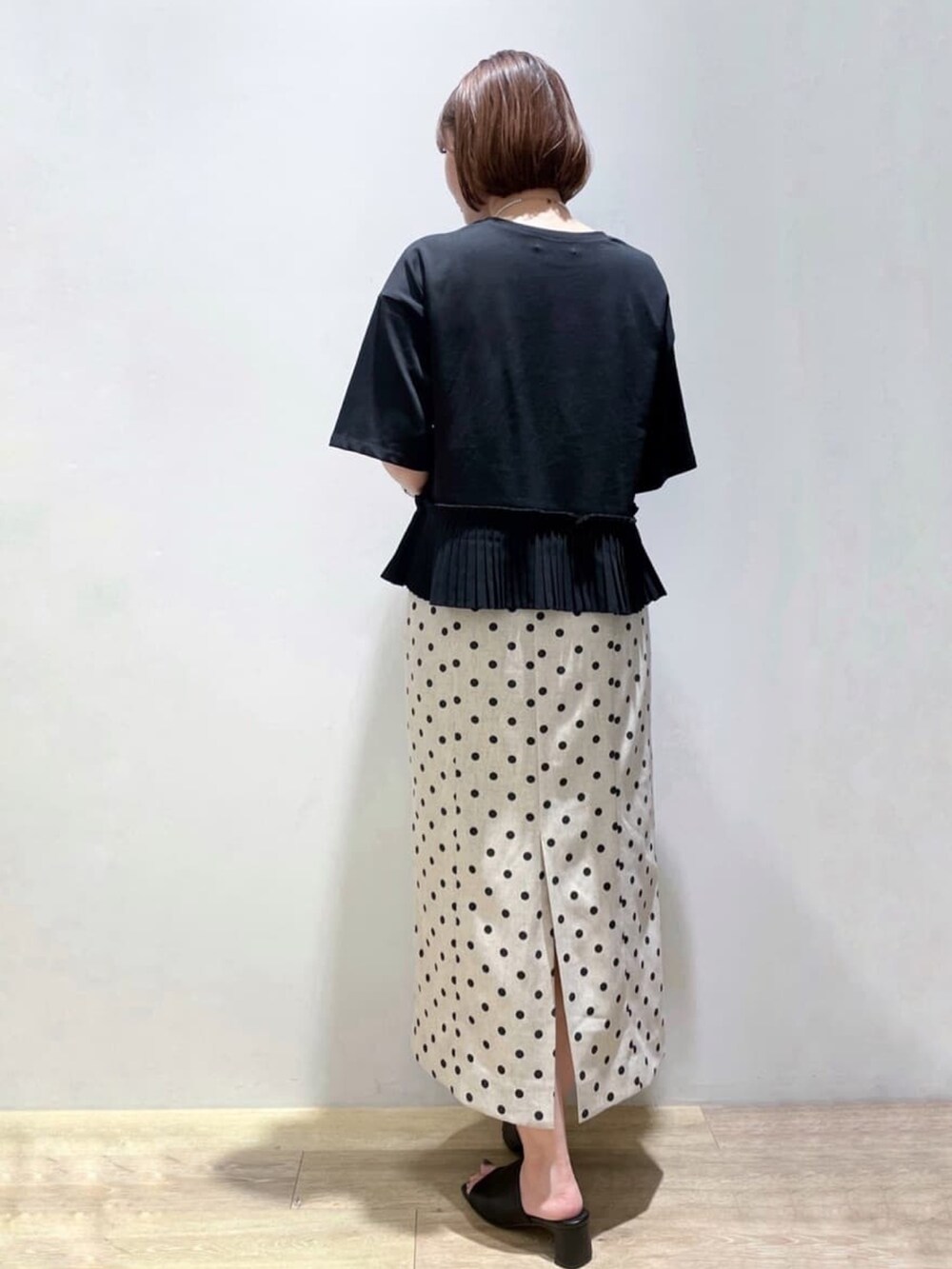 ベージュ系のスカート、ブラック系のTシャツ/カットソー、ブラック系のサンダルを着用したレディースの夏コーディネートの4枚目の写真