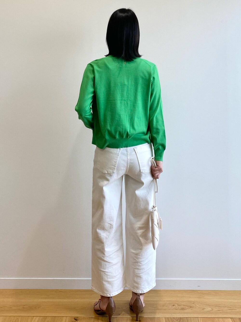 ブラック系のサンダル、ホワイト系のショルダーバッグ、ホワイト系のデニムパンツを着用したレディースの春コーディネートの3枚目の写真