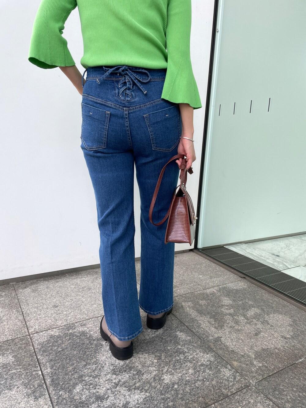 グリーン系のニット/セーター、ブルー系のその他パンツ、ブラウン系のショルダーバッグを着用したレディースの秋コーディネートの5枚目の写真