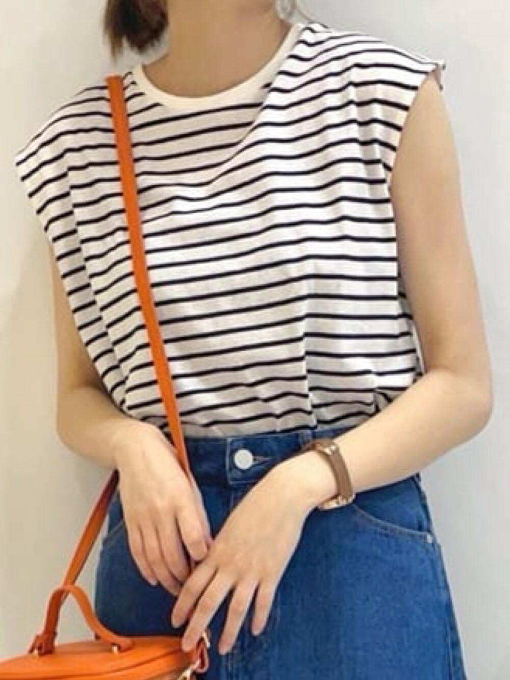 ホワイト系のTシャツ/カットソー、ブルー系のスカート、レッド系のショルダーバッグを着用したレディースの春コーディネートの2枚目の写真