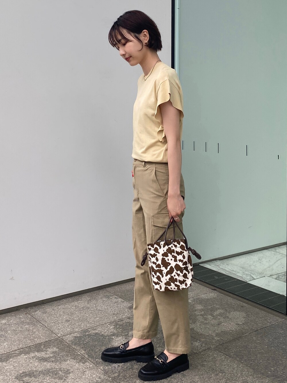 ベージュ系のその他パンツ、ブラウン系のショルダーバッグ、イエロー系のニット/セーターを着用したレディースの夏コーディネートの2枚目の写真