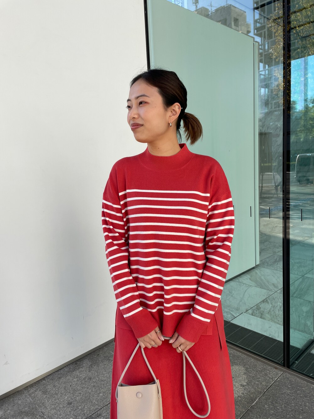 レッド系のニット/セーター、レッド系のスカート、ベージュ系のブーツを着用したレディースの冬コーディネートの4枚目の写真