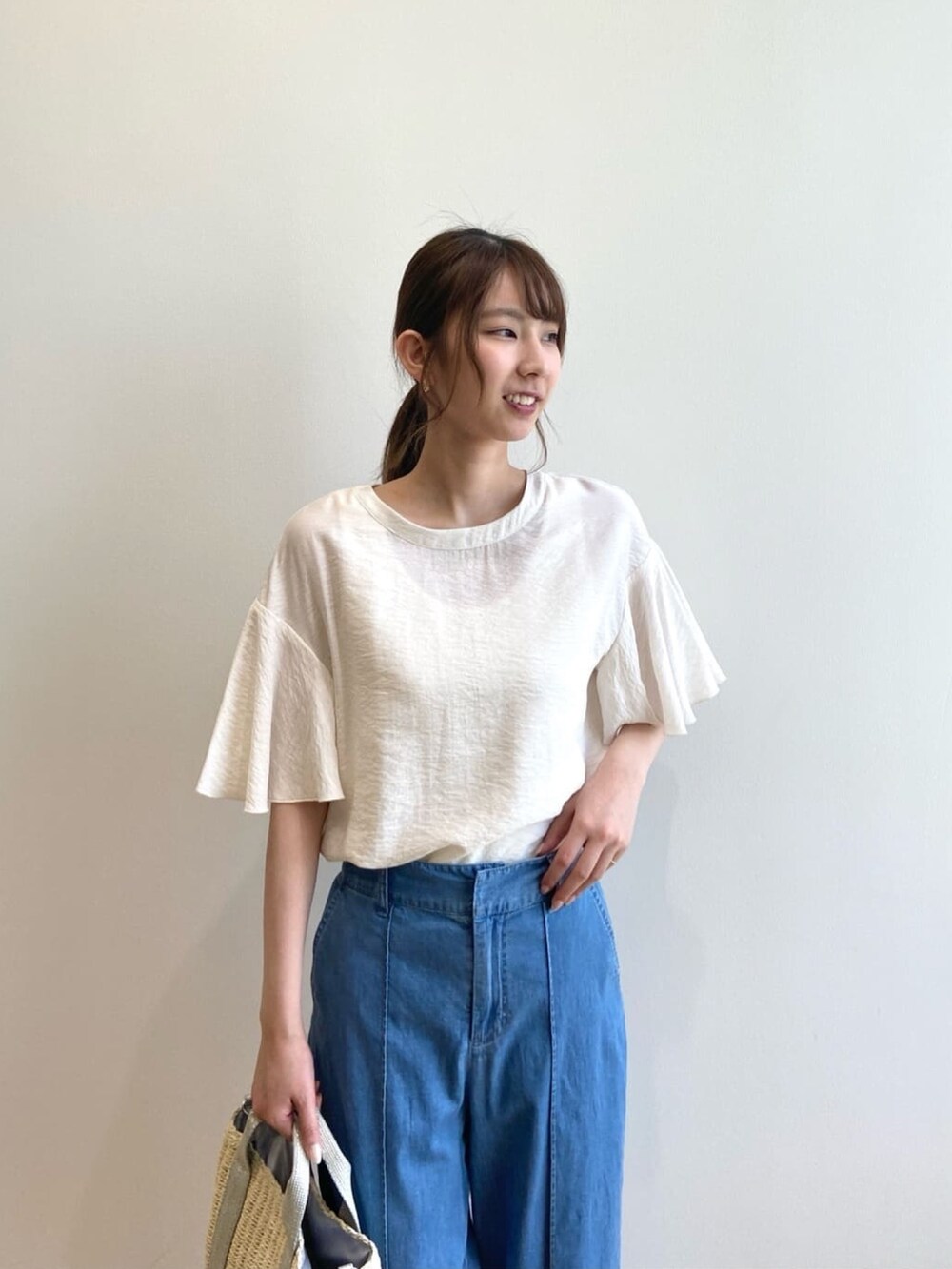 ホワイト系のシャツ/ブラウス、ブルー系のデニムパンツ、シルバー系のショルダーバッグを着用したレディースの夏コーディネートの7枚目の写真