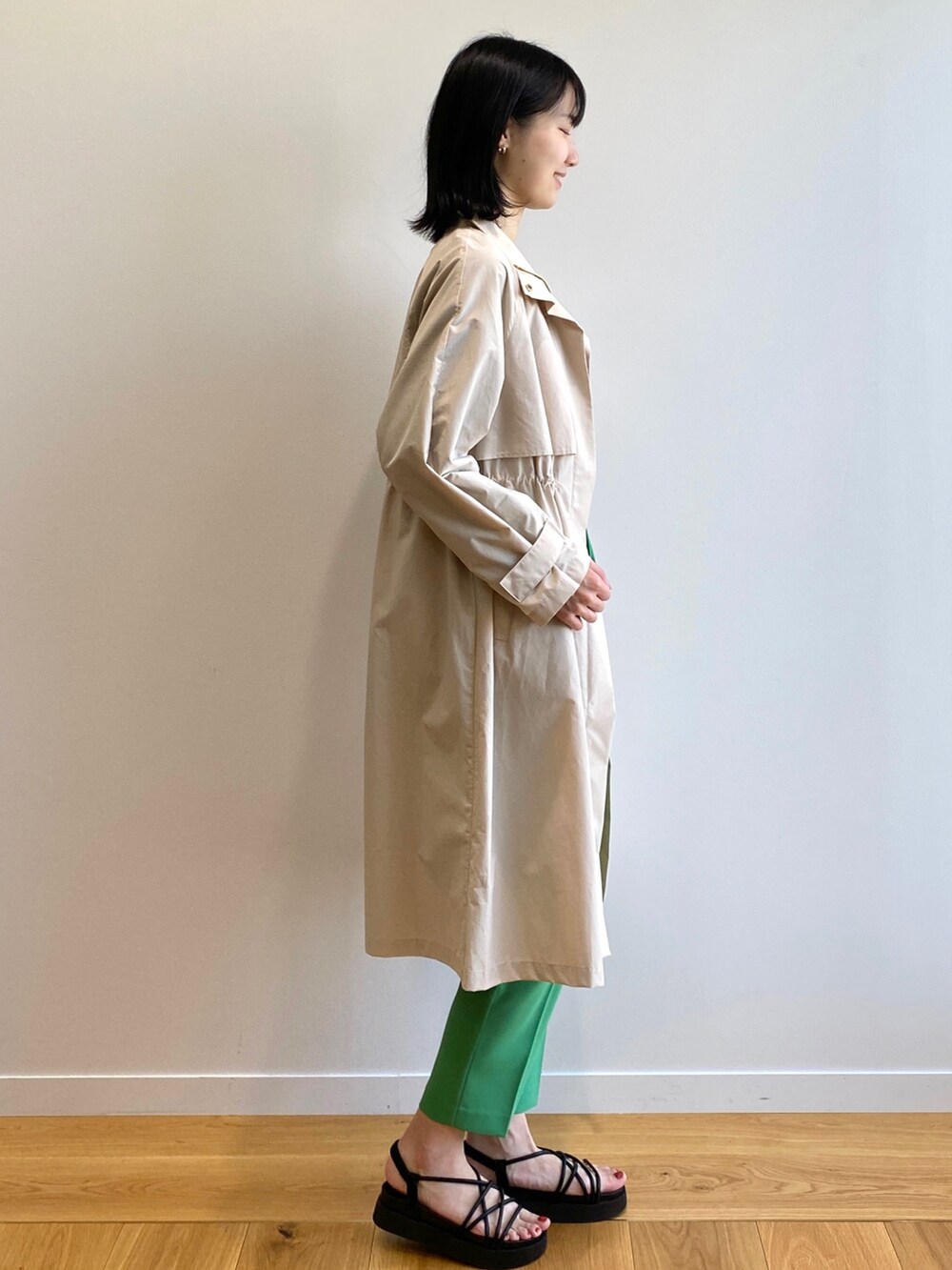 ブラック系のサンダル、グリーン系のその他パンツ、ベージュ系のトレンチコートを着用したレディースの春コーディネートの2枚目の写真