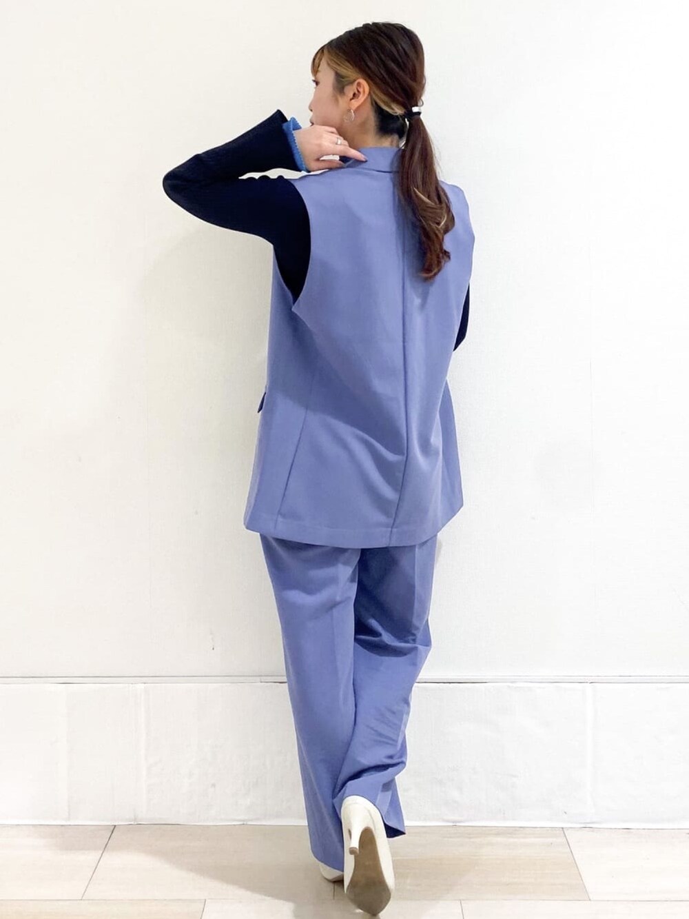 ブルー系のベスト、ブルー系のその他パンツ、ホワイト系のパンプスを着用したレディースの春コーディネートの3枚目の写真