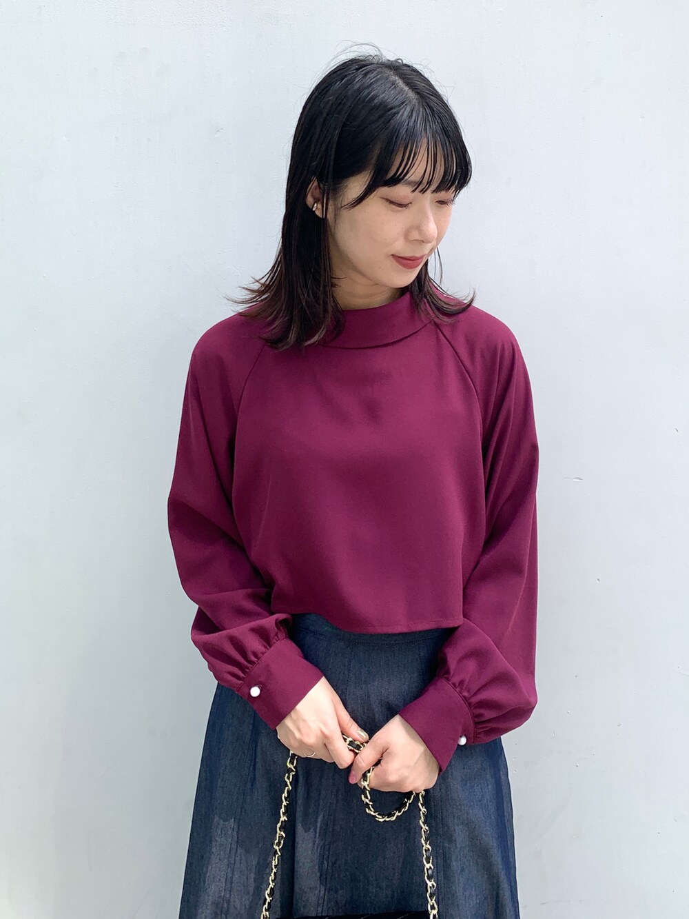 パープル系のシャツ/ブラウス、ブルー系のスカート、ブラック系のショルダーバッグを着用したレディースの秋コーディネートの3枚目の写真