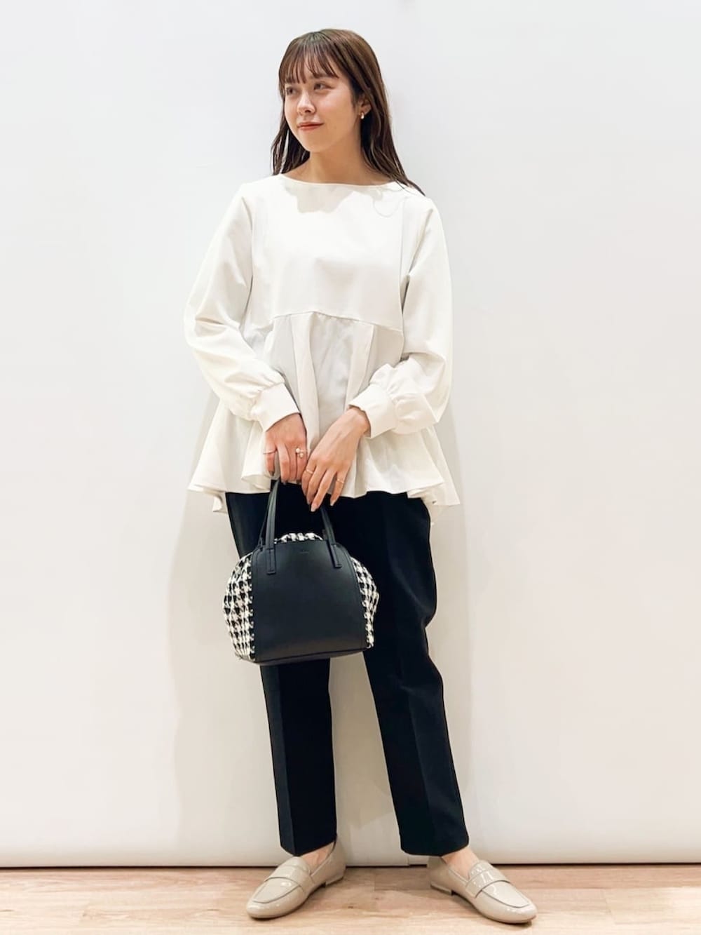 ホワイト系のTシャツ/カットソー、ブラック系のその他パンツ、ブラック系のトートバッグを着用したレディースの冬コーディネートの2枚目の写真