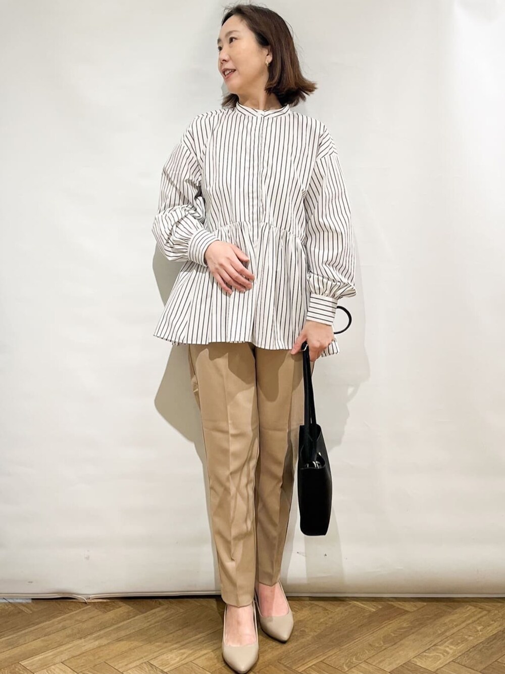 ベージュ系のその他パンツ、グレー系のトートバッグ、ベージュ系のパンプスを着用したレディースの春コーディネートの4枚目の写真