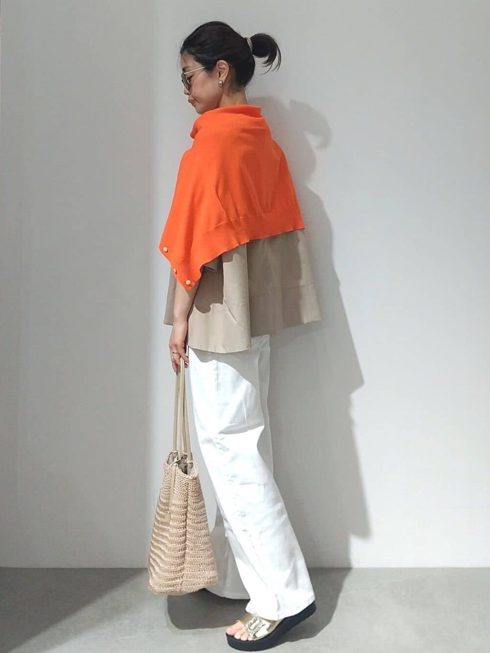 ベージュ系のTシャツ/カットソー、オレンジ系のカーディガン/ボレロ、ホワイト系のデニムパンツを着用したレディースの春コーディネートの2枚目の写真