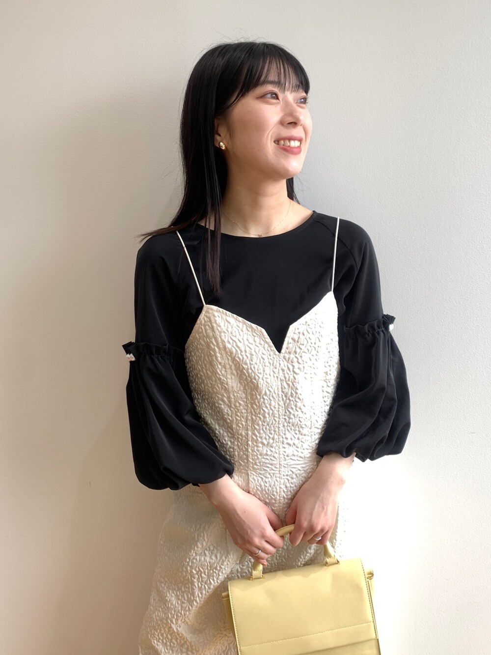 ホワイト系のワンピース、ブラック系のシャツ/ブラウス、イエロー系のショルダーバッグを着用したレディースの春コーディネートの4枚目の写真