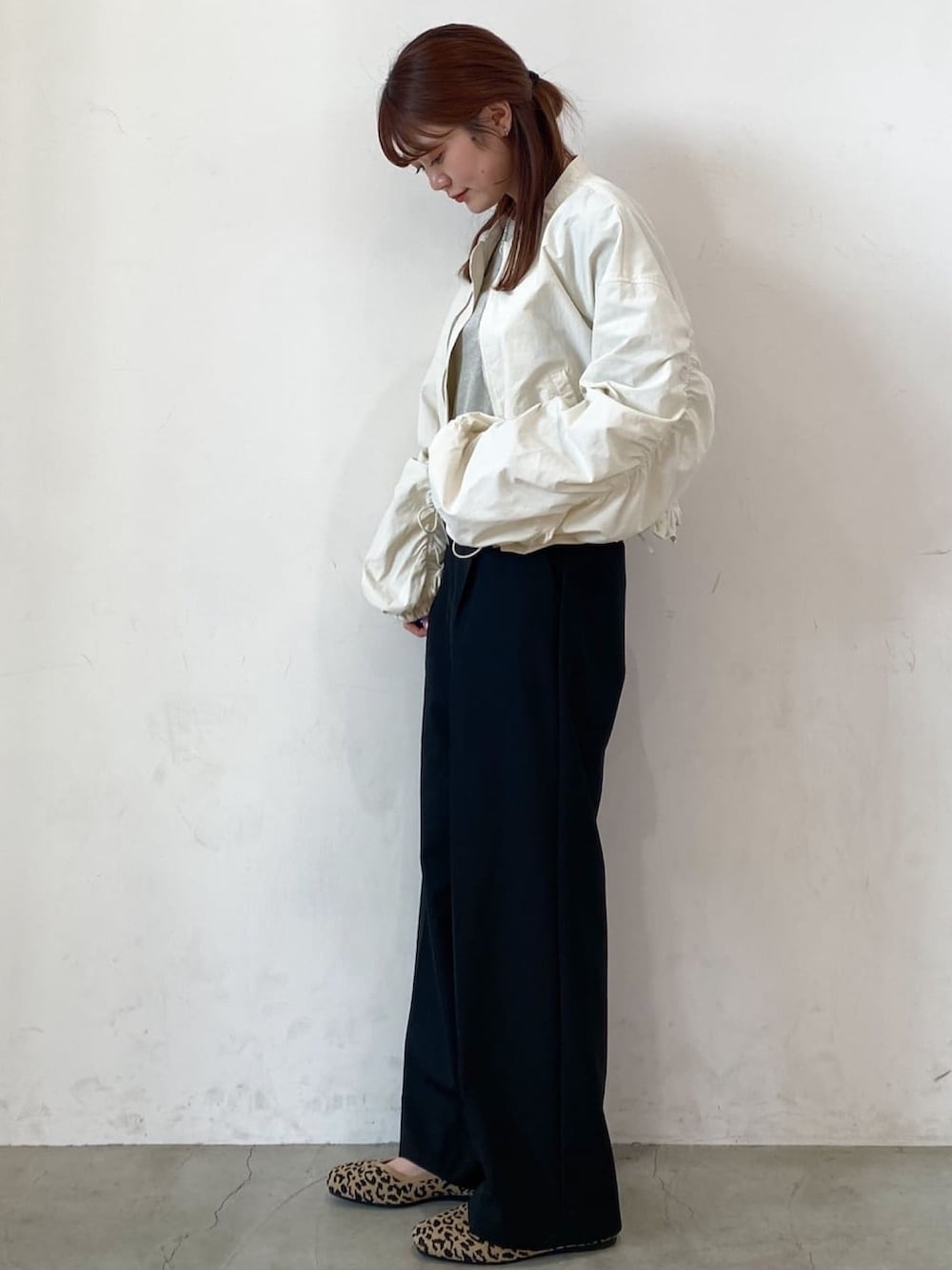 ホワイト系のブルゾン、ブラック系のその他パンツ、ベージュ系のTシャツ/カットソーを着用したレディースの春コーディネートの2枚目の写真