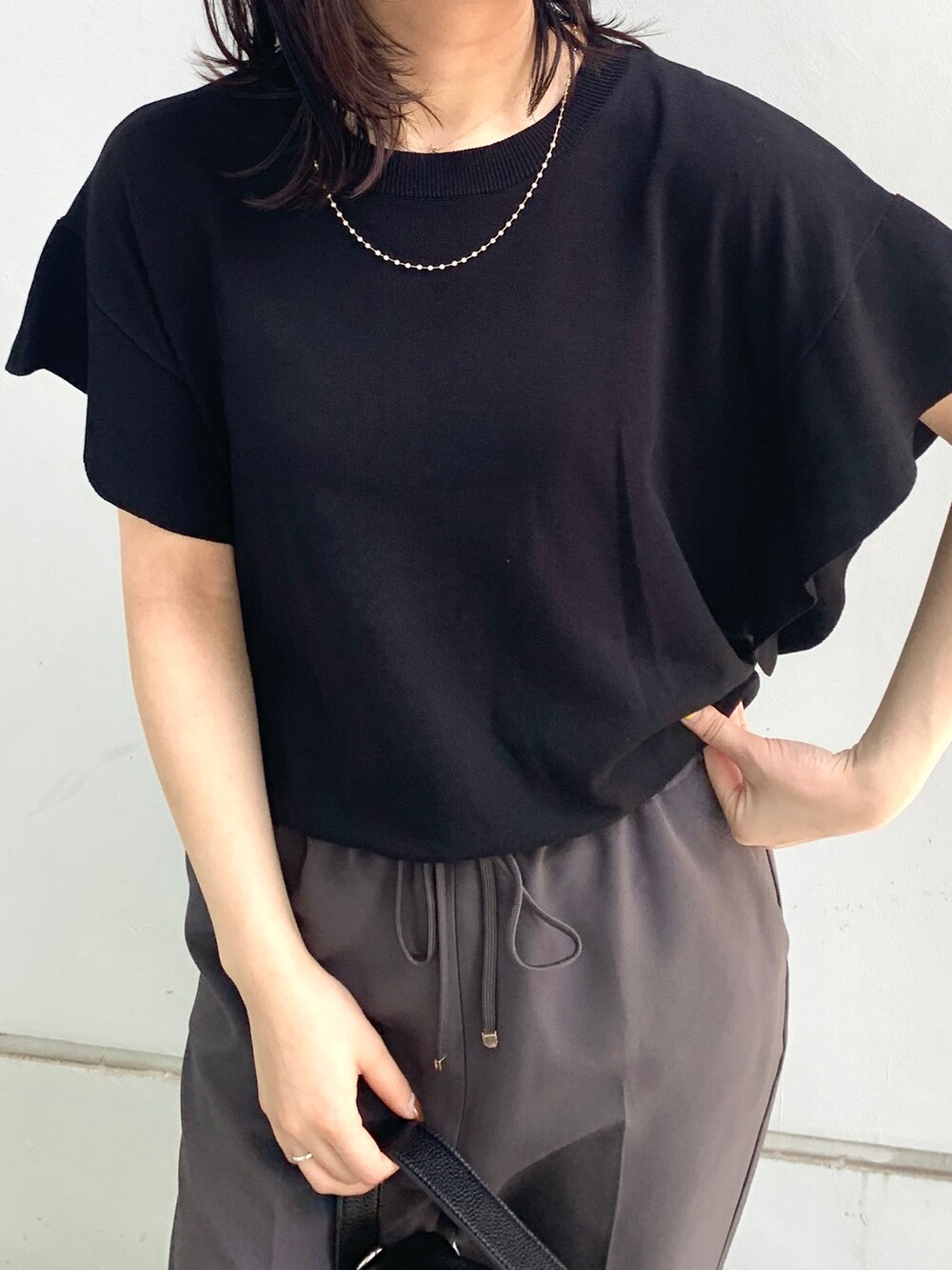 ブラック系のニット/セーター、ブラック系のその他パンツ、ブラック系のシューズを着用したレディースの夏コーディネートの4枚目の写真