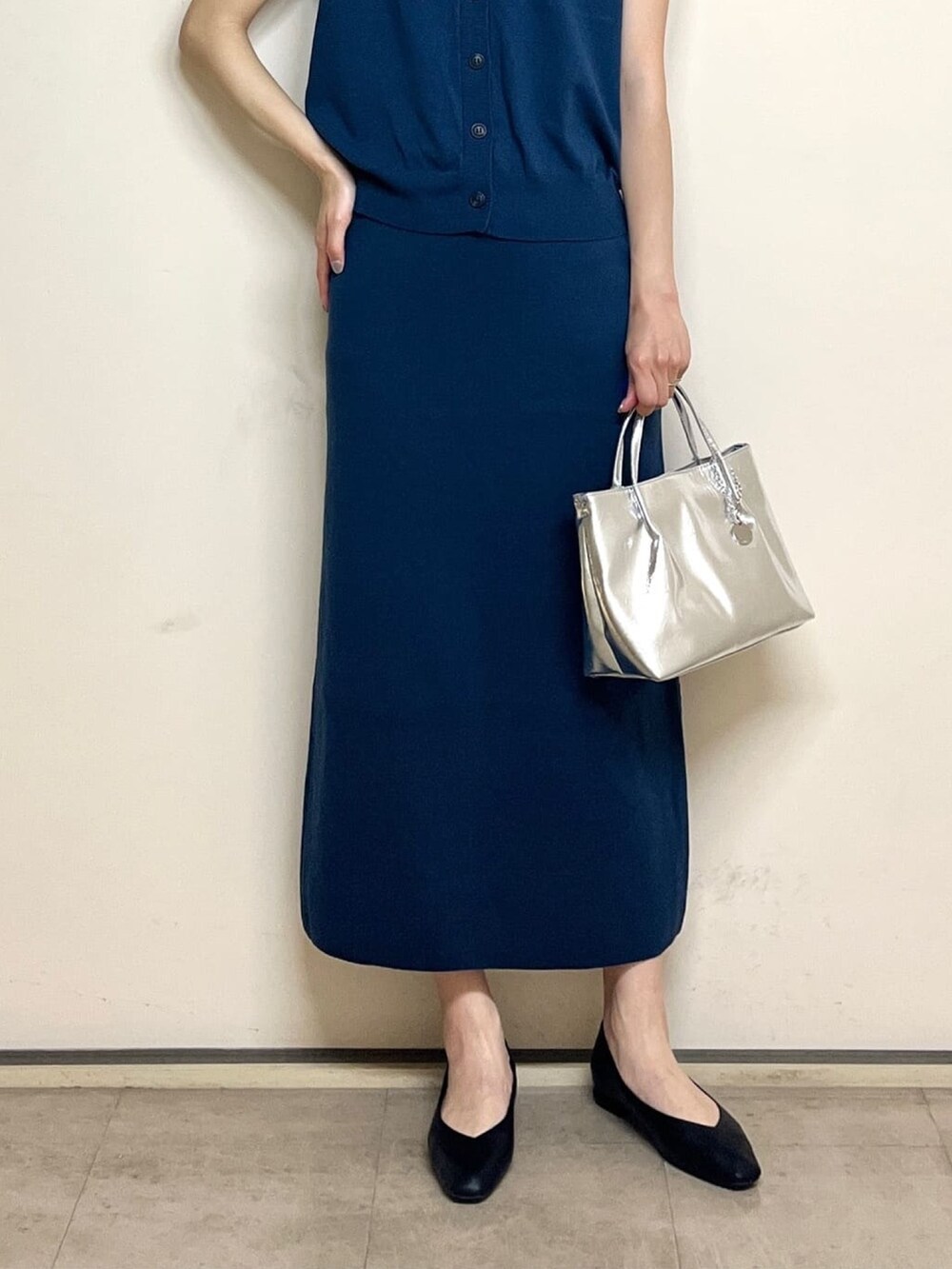 ブルー系のベスト、ブルー系のスカート、シルバー系のトートバッグを着用したレディースの夏コーディネートの6枚目の写真